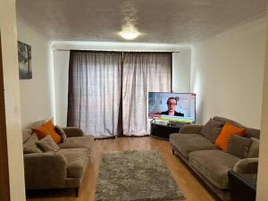 a living room with a couch and a flat screen tv at 30% Off Monthly Stay/2bed /Erith in Erith