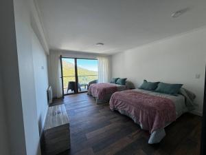 - une chambre avec 2 lits, une fenêtre et un canapé dans l'établissement Sweet catedral II, à San Carlos de Bariloche
