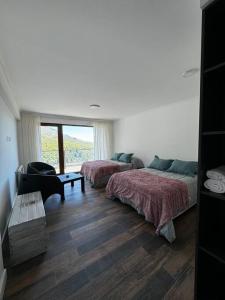 - une chambre avec 2 lits, un canapé et une fenêtre dans l'établissement Sweet catedral II, à San Carlos de Bariloche