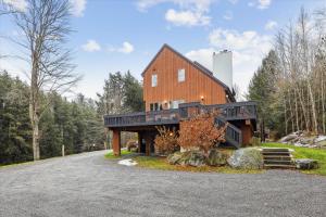 uma casa de celeiro com um alpendre à volta em Stonybrook 79 em Stowe