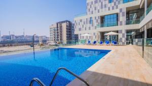 - une piscine sur le côté d'un bâtiment dans l'établissement Duplex Delight in Al Raha, à Abu Dhabi