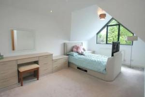 una camera con letto, scrivania e specchio di Luxury house in solihull a Olton