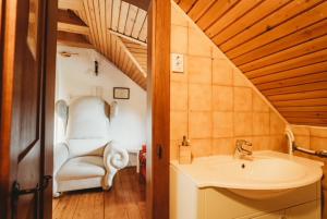 łazienka z umywalką i krzesłem w pokoju w obiekcie Inhauser Pincészet&Guesthouse&Restaurant w mieście Somlószőlős +10 zdjęć