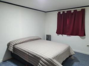 uma cama num quarto com uma janela vermelha em Los manzanares, casa histórica em Veintiocho de Noviembre