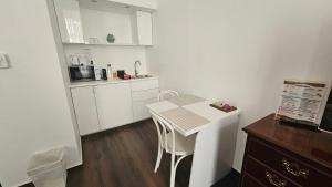 a small white kitchen with a table and chairs at OPERA16 Guestrooms in Budapest