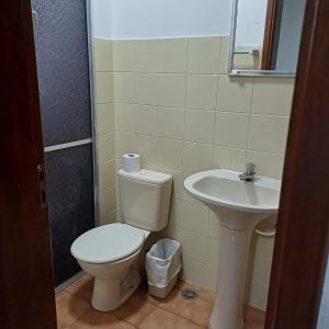 a bathroom with a toilet and a sink at Hotel Firenze in Londrina