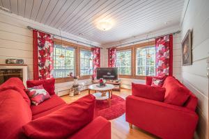 ein Wohnzimmer mit roten Sofas und einem TV in der Unterkunft Toukola by Hi Ylläs in Ylläsjärvi