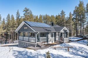 ein Haus mit Sonnenkollektoren auf dem Dach im Schnee in der Unterkunft Toukola by Hi Ylläs in Ylläsjärvi