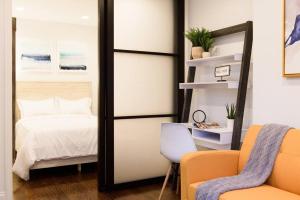 um quarto com uma cama, um espelho e uma cadeira em 69-3A Prime LES Modern Brand New 1BR em Nova Iorque