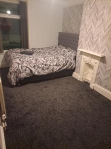 Rooms to rent in a shared house - Short & Long Stay في هدرسفيلد: غرفة نوم فيها سرير وموقد