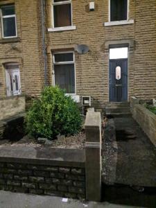 un edificio de ladrillo con una puerta y un arbusto en Rooms to rent in a shared house - Short & Long Stay en Huddersfield