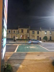 a car driving past a parking lot at night at Rooms to rent in a shared house - Short & Long Stay in Huddersfield