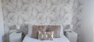 a bedroom with a white tufted headboard and a bed with pillows at Casa acogedora Mar de Albariño con Piscina in Cambados