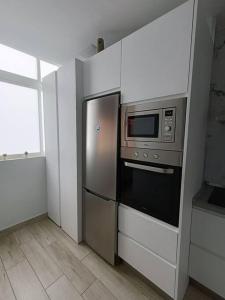 uma cozinha com um frigorífico de aço inoxidável e um micro-ondas em Buenavista5 em Las Palmas de Gran Canaria