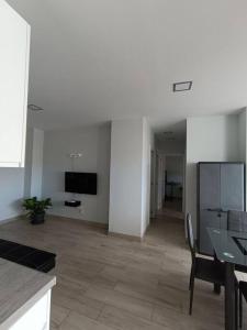 a living room with a table and a tv on the wall at Buenavista5 in Las Palmas de Gran Canaria