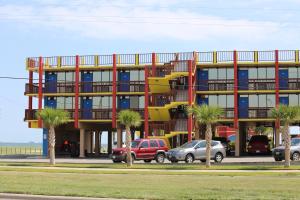 un bâtiment avec des palmiers en face de celui-ci dans l'établissement Hotel DeVille, à Corpus Christi