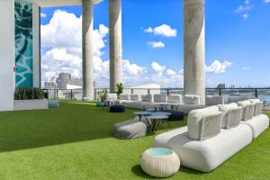 a room with white chairs and a green field of grass at Stylish Condo near Bayside Park: Amazing Views Await in Miami