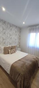 1 dormitorio con 1 cama grande y cabecero grande en Casa acogedora Mar de Albariño con Piscina, en Cambados