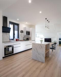 a kitchen with white cabinets and a wooden floor at Monte Carlo Monaco Border - luxury, modern, cozy with home feelings and See View in Beausoleil