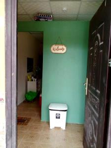 a bathroom with a toilet and a green wall at Mini apartamento Penonomé in Penonomé