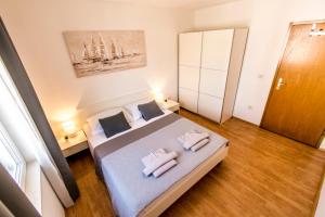 1 dormitorio con 1 cama con 2 toallas en Apartments Ćurić, en Trogir