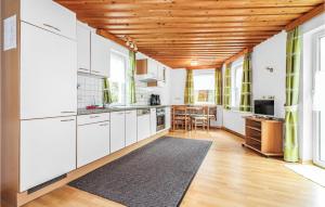 トバーディルにあるStunning Apartment In Tobadill With 1 Bedrooms And Wifiの白いキャビネットと木製の天井が備わるキッチン