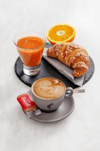 eine Tasse Kaffee, ein Gebäck und ein Glas Orangensaft in der Unterkunft Giagi B&B in Trient