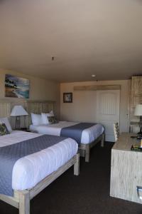 a hotel room with two beds and a table at Hotel DeVille in Corpus Christi