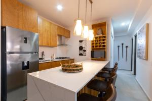 eine Küche mit einer großen weißen Theke und einem Kühlschrank in der Unterkunft Bluu Lagoon-Hermoso depa con playa privada in Mazatlán