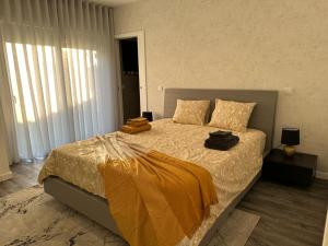 a bedroom with a large bed with yellow sheets at Alojamento Gândara in Praia de Mira