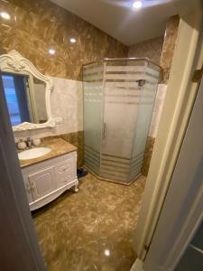 bagno con doccia, lavandino e specchio di Baku - Park Azure with sea view two bedrooms and one living room a Baku