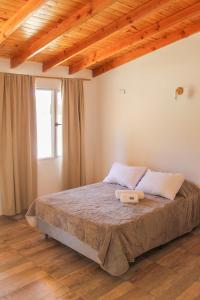 um quarto com uma cama grande e um tecto em madeira em Tierra Patagonica Departamentos em El Bolsón