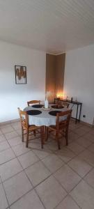 uma sala de jantar com uma mesa e quatro cadeiras em Au Bon Accueil em Feuquières