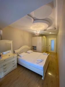 um quarto com uma grande cama branca e uma cómoda em Baku - Park Azure with sea view two bedrooms and one living room em Baku