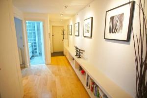 a hallway with a shelf of books on a wall at Superior Canary Wharf O2 Arena 2Bed Apartment in London