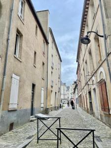 an empty street with two benches in an alley at Le Cosy, charmant studio centre ville in Rennes