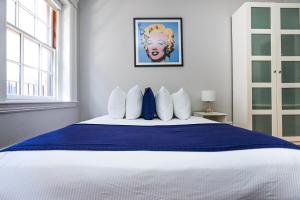 um quarto com uma cama grande e almofadas azuis e brancas em Charming & Stylish Studio on Beacon Hill #9 em Boston