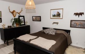 a bedroom with a bed and a chandelier at Grandma's cottage in Tanum +33 photos