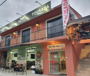グァラトゥバにあるPousada Mar e Motoのテーブルと椅子のあるレストランを併設する建物