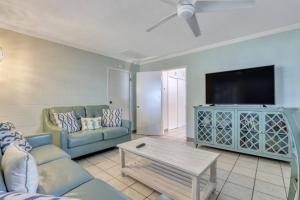 Una sala de estar con un sofá y un televisor de pantalla plana. en Gem by the Beach Unit A Walk to Beach, Shops, Bars, en Tybee Island