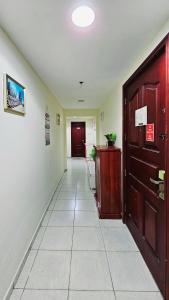 a hallway with a door and a tile floor at Anju's sweet Stay in Sharjah