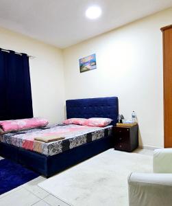 a bedroom with a blue bed and a night stand at Anju's sweet Stay in Sharjah