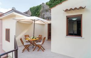 Torraca的住宿－Cozy Home In Torraca With Wifi，庭院内桌椅和遮阳伞
