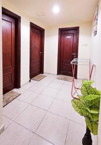 a hallway with two doors and a plant at Anju's sweet Stay in Sharjah