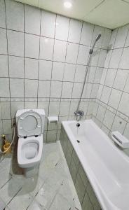 ein Badezimmer mit einem WC und einer Badewanne in der Unterkunft Anju's sweet Stay in Schardscha