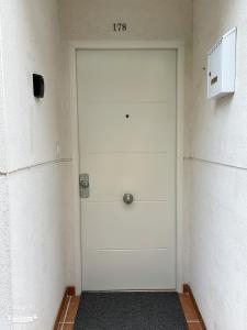 Una puerta blanca en una habitación con un cartel. en Villa con patio en Madrid