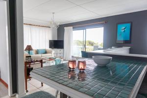a living room with a table with two glasses on it at 7Onthebeach in Jeffreys Bay