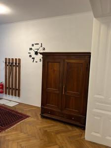 Pokój z drewnianą szafką i zegarem na ścianie w obiekcie Paky Appartements 00406 w Wiedniu