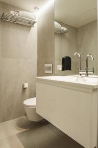 La salle de bains est pourvue d'un lavabo blanc et de toilettes. dans l'établissement Apto Ribeira Lisboa, à Lisbonne