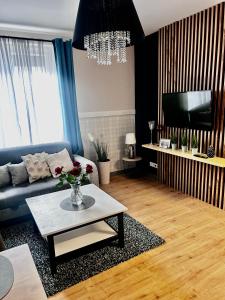 Apartament Walczaka 46 MIEJSCE PARKINGOWE في جورزو فيلكوبولسكي: غرفة معيشة مع أريكة وطاولة